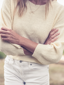 Detailed view of a daffodil yellow sweater's textured knit, styled casually with white denim shorts for a summer look.