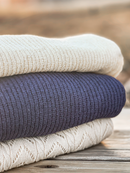 Stacked sweaters featuring a daffodil yellow, navy blue, and cream chevron knit, creating a cozy, layered aesthetic.