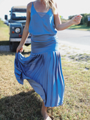A detailed close-up of a flowing blue pleated skirt paired with a coordinating cami, showcasing movement and texture.